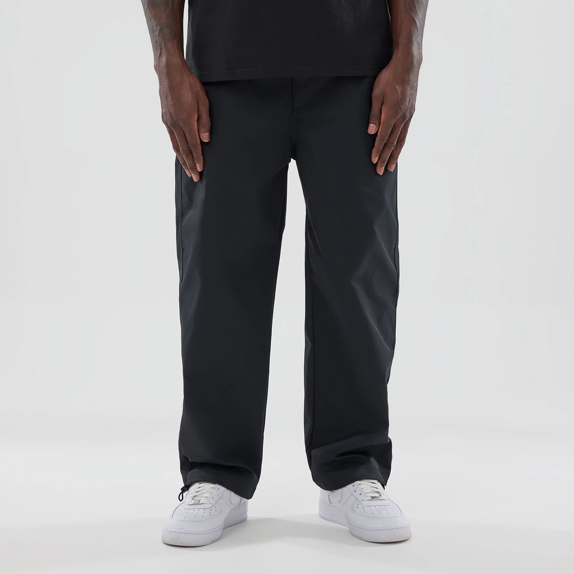 The model is wearing this New Era NEC Logo Straight Leg Joggers in black. 1