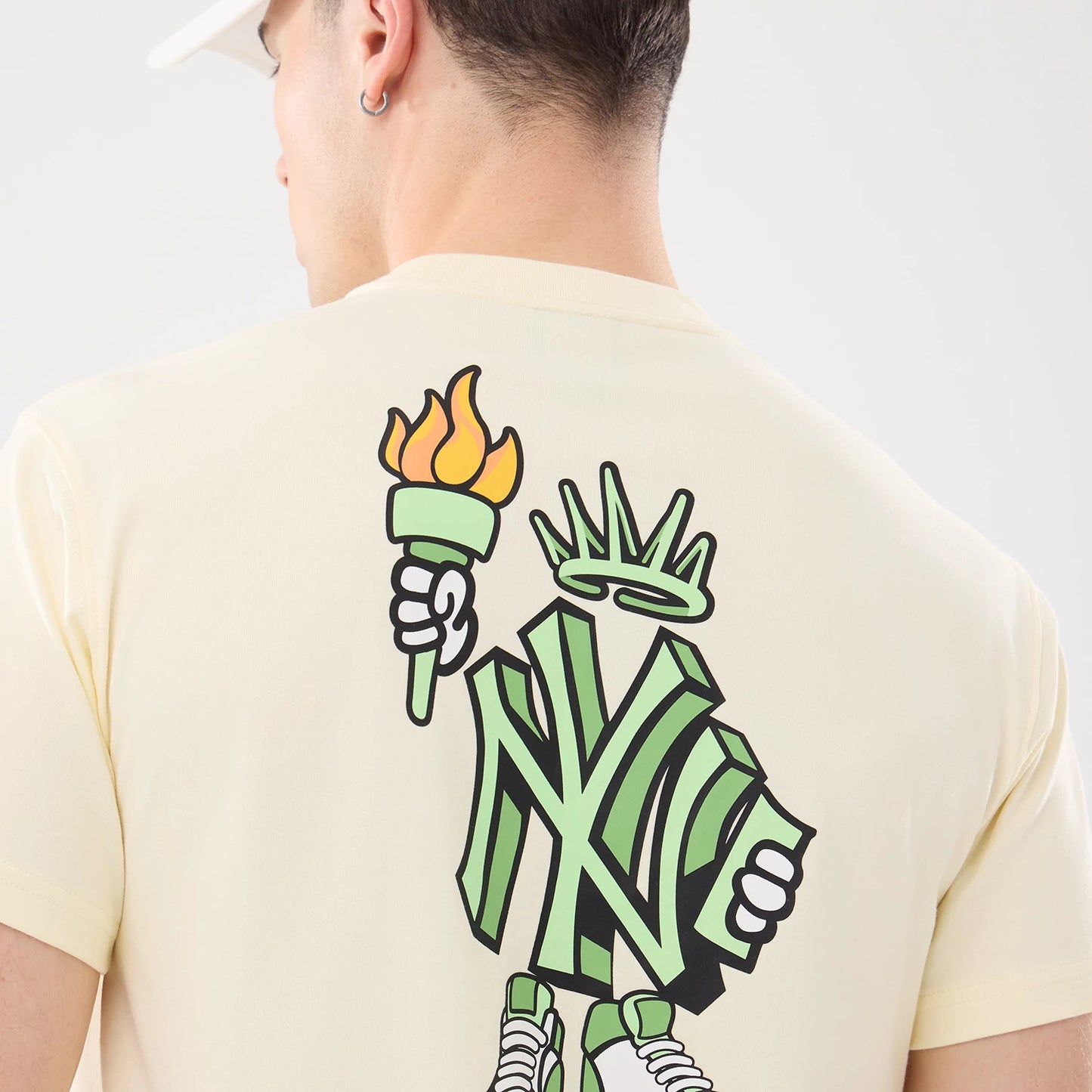 The model is wearing this MLB Cartoon New York Yankees T-Shirt in cream. 7