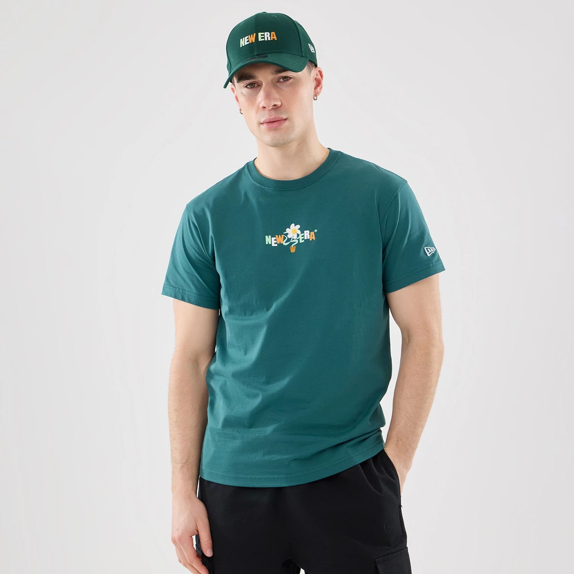 The model is wearing this New Era Earth Day T-Shirt in dark green. 1
