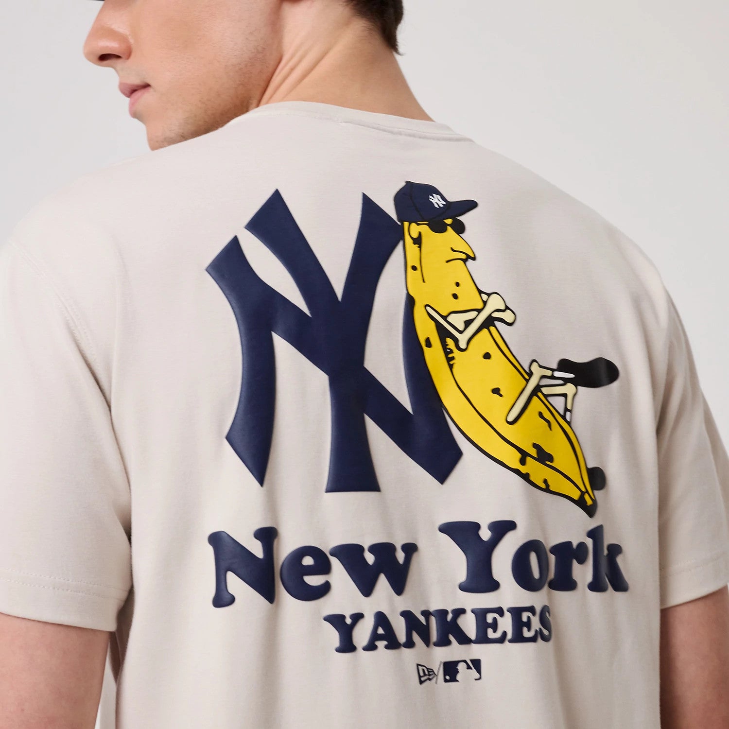 The model is wearing this MLB Banana Graphic New York Yankees T-Shirt in natural. 3