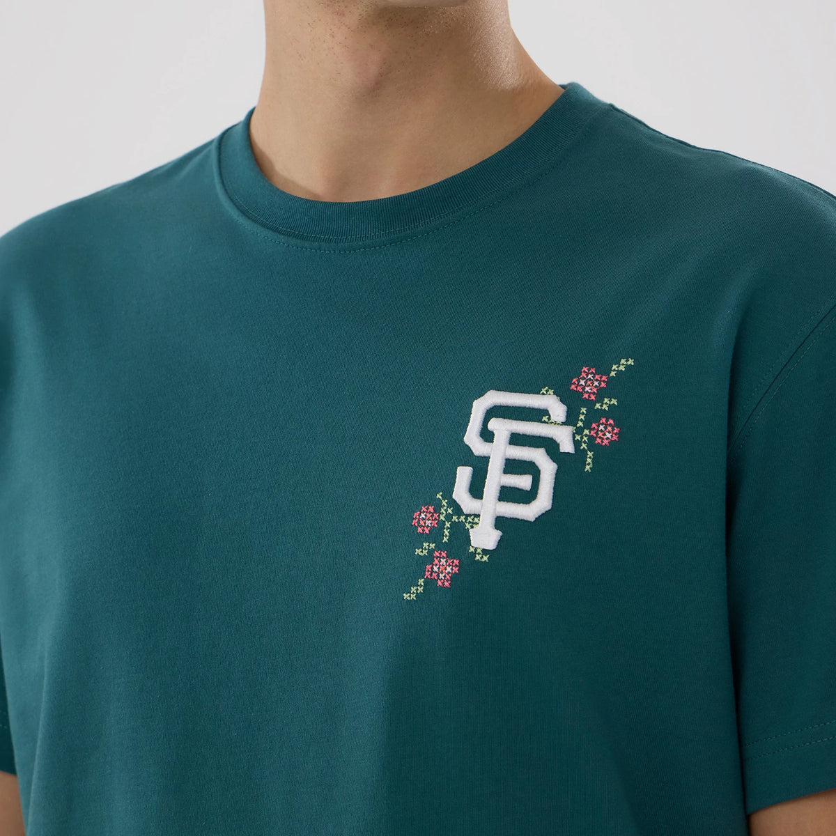 San Francisco Giants MLB Garden Dark Green T-Shirt, front view showing the dark green fabric with an embroidered white "SF" logo on the left chest, surrounded by floral accents in pink and green.