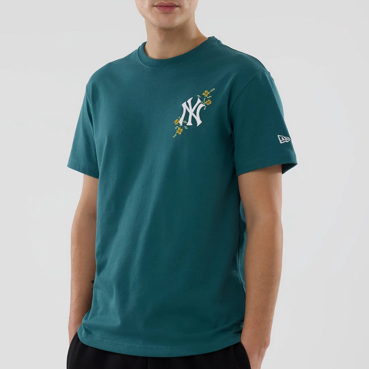 New York Yankees MLB Garden Dark Green T-Shirt, front view showing a dark green short-sleeve T-shirt with a white New York Yankees logo and floral design on the chest, and a debossed New Era logo on the left sleeve.