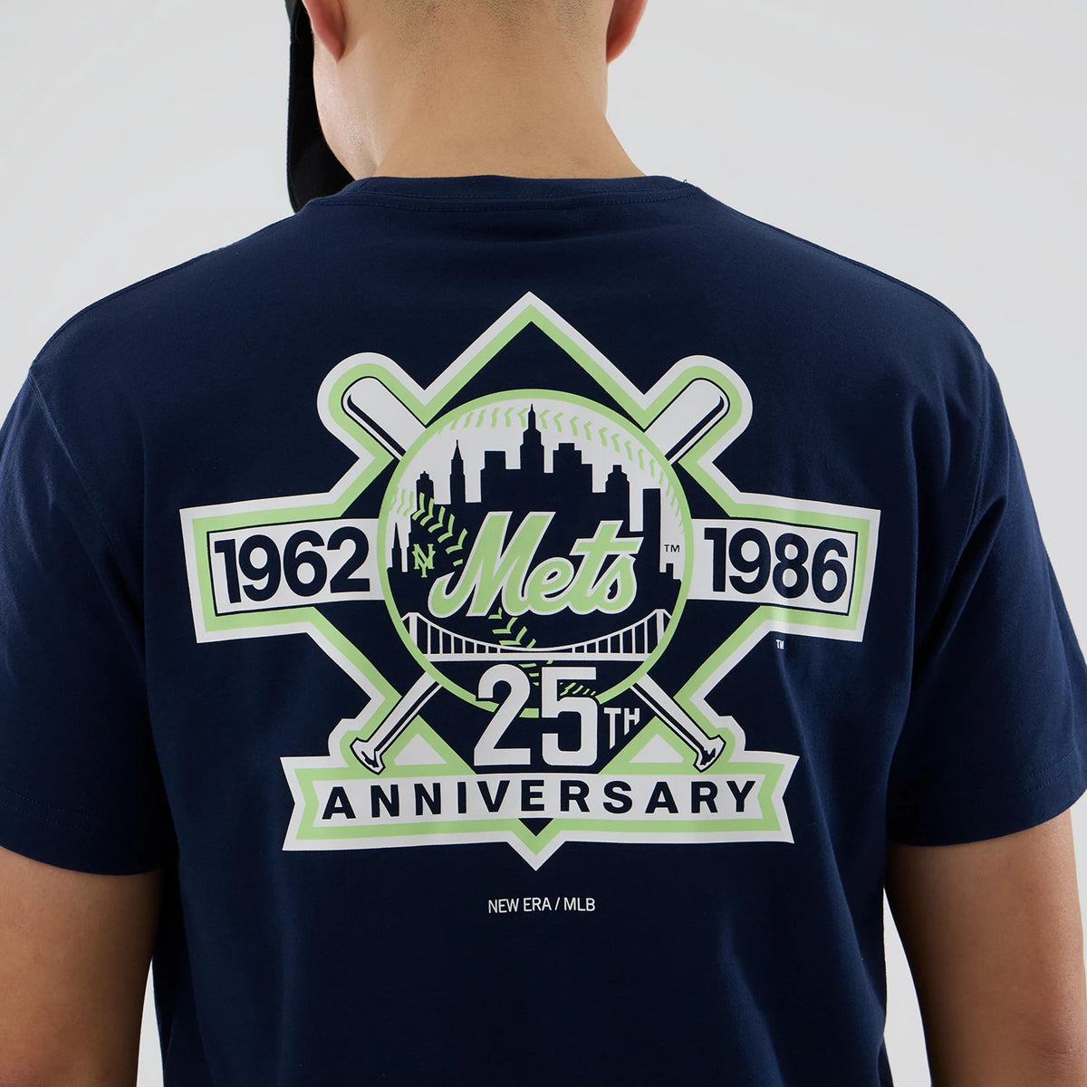 New York Mets MLB Garden Blue T-Shirt, rear view showing a large printed logo featuring the Mets skyline and baseball design with crossed bats, the years 1962 and 1986, and the text '25th Anniversary' in bold lettering.