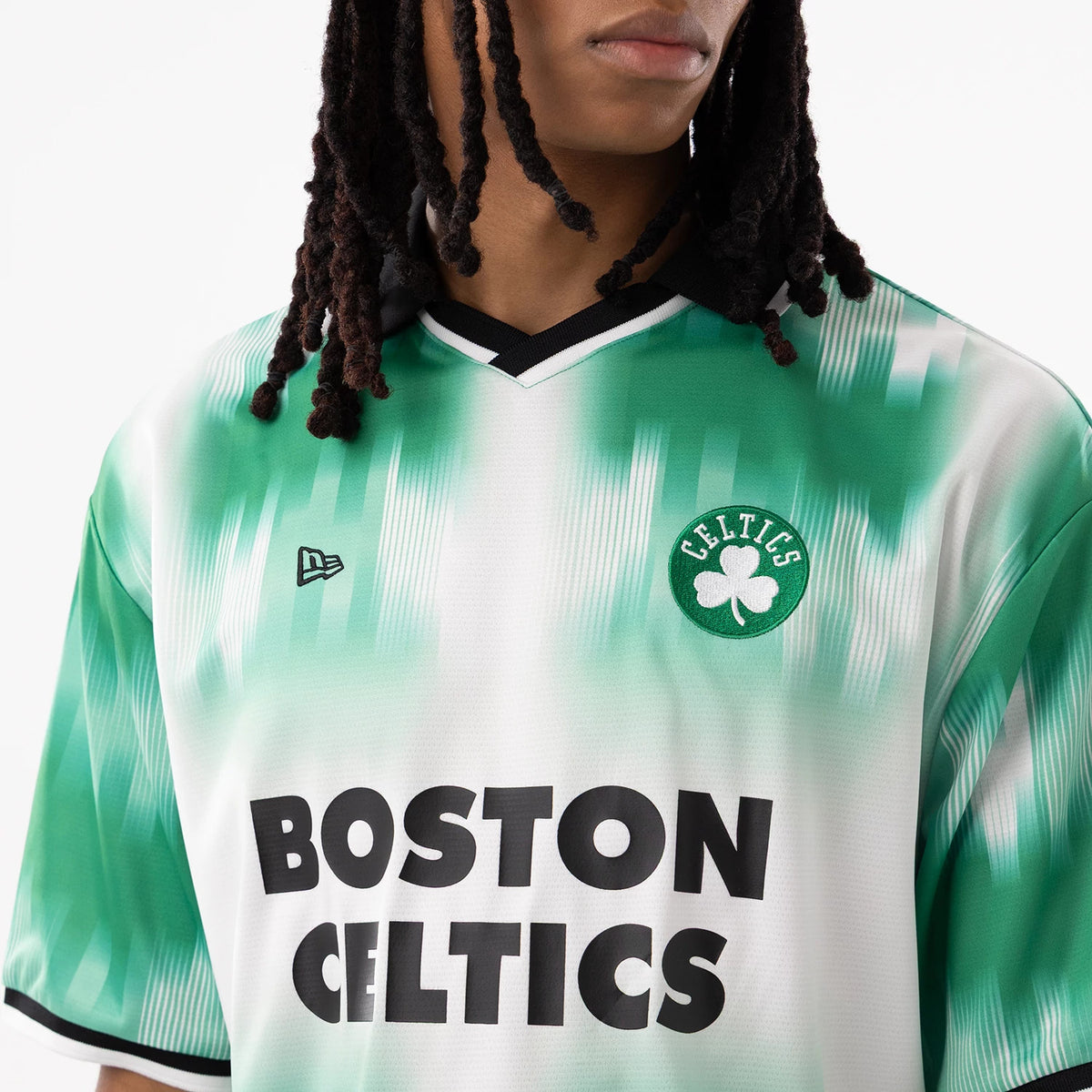 Boston Celtics NBA Green Soccer Jersey, front view on a model showing the Celtics cloverleaf patch on the left chest, black New Era flag logo on the right chest, and black lettering across the front.