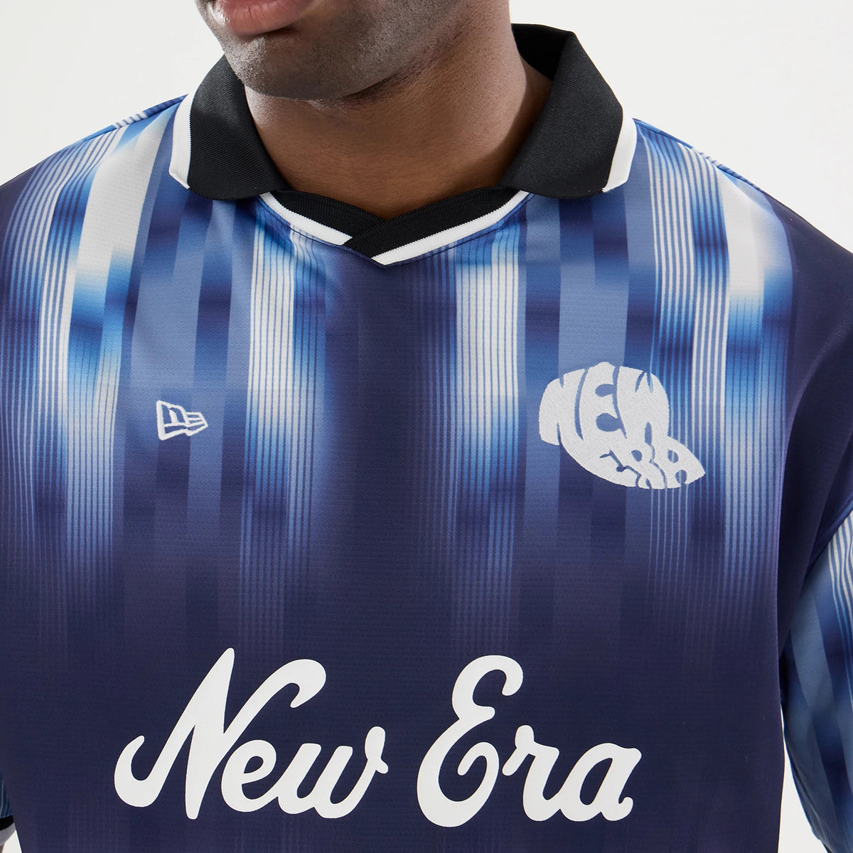 New Era Navy Soccer Jersey, three-quarter view on a model showing a gradient blue stripe pattern with a black collar, featuring a white New Era wordmark across the chest and the New Era flag logo on the left side.