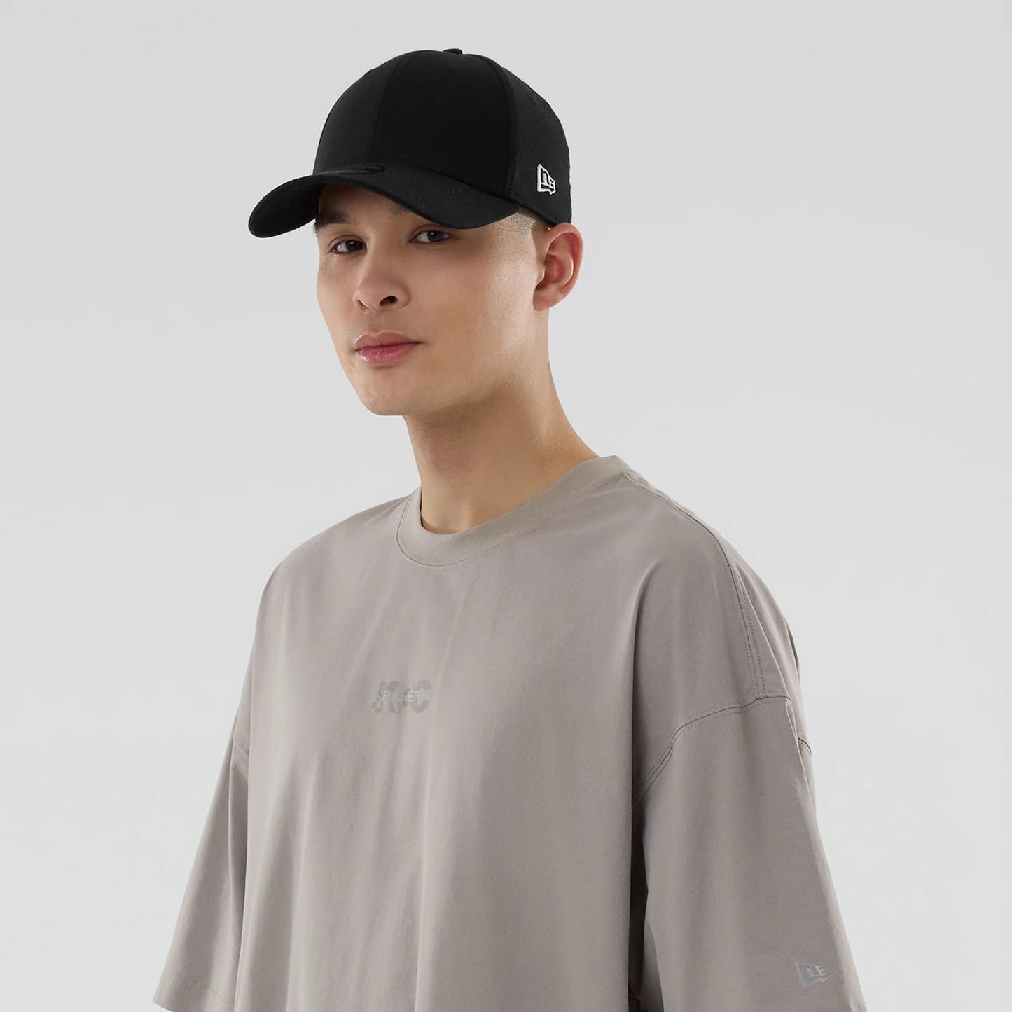 The model is wearing this New Era NEC Logo Oversized T-Shirt in Beige. 7