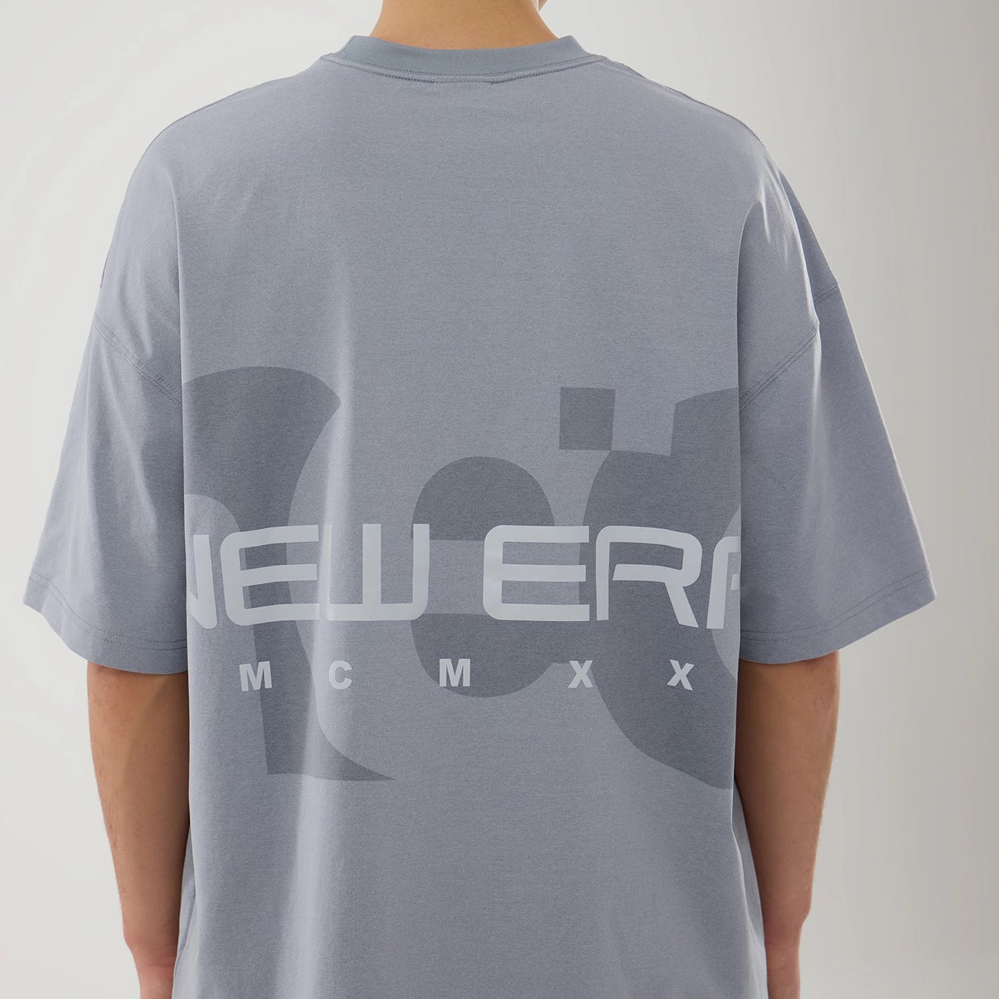 The model is wearing this New Era NEC Logo Oversized T-Shirt in grey. 7