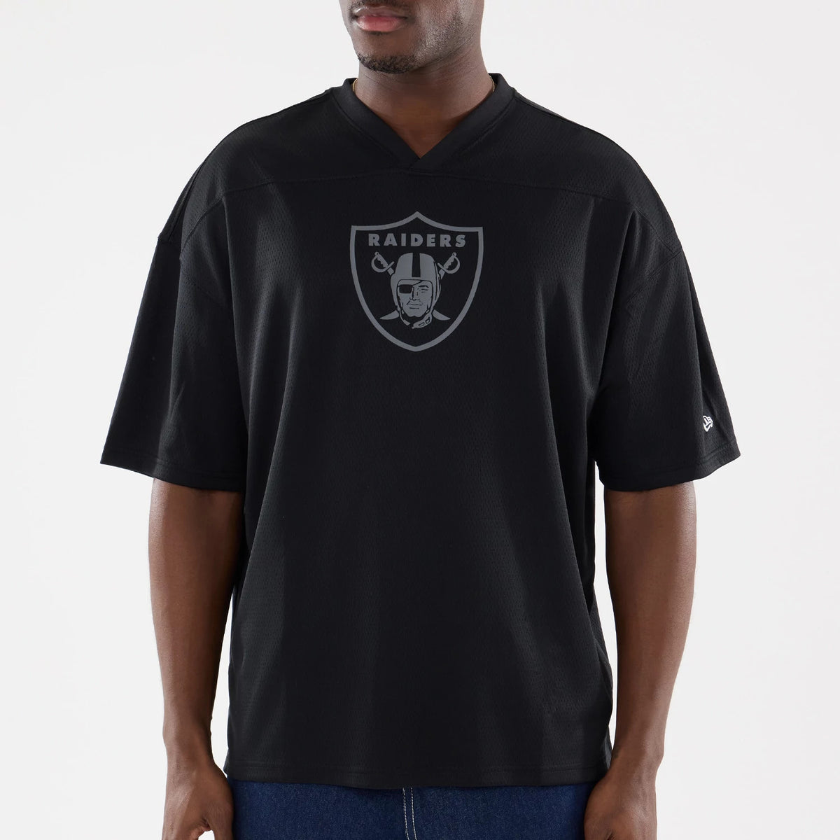 Las Vegas Raiders NFL Raiders Wear Black Mesh Oversized T-Shirt, front view showing the large grey Raiders shield logo with a raised finish centred on the chest and a small raised New Era logo on the left sleeve.