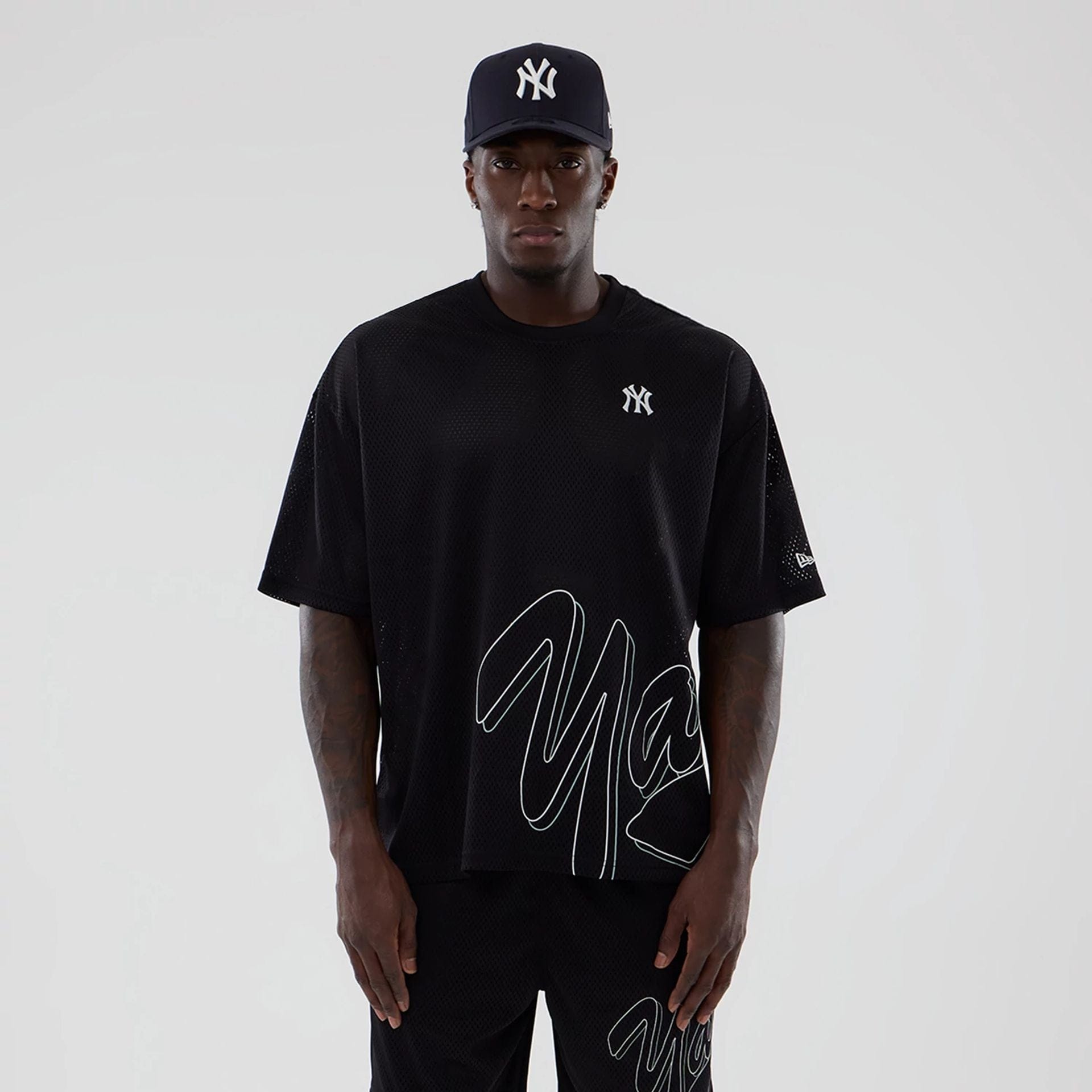 The model is wearing this MLB Mix League New York Yankees Oversized Mesh T-Shirt in black. 1
