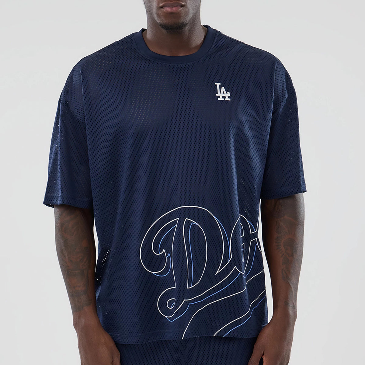 LA Dodgers MLB Mix League Blue Oversized Mesh T-Shirt, front view featuring a navy blue mesh fabric with a raised LA logo on the left chest and a large white outlined Dodgers script across the lower front.