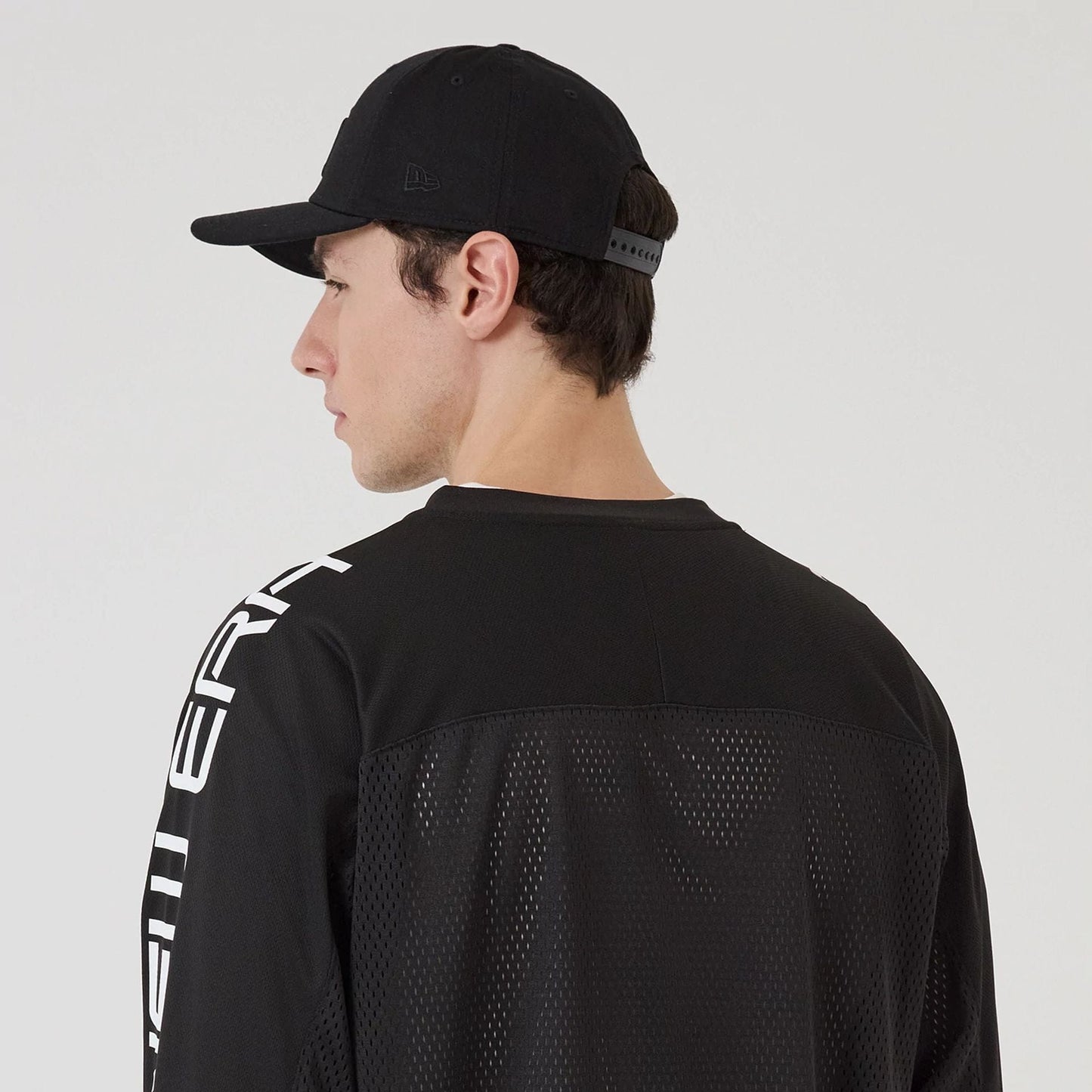 The model is wearing this New Era NEC Logo Long Sleeve Jersey in black. 7