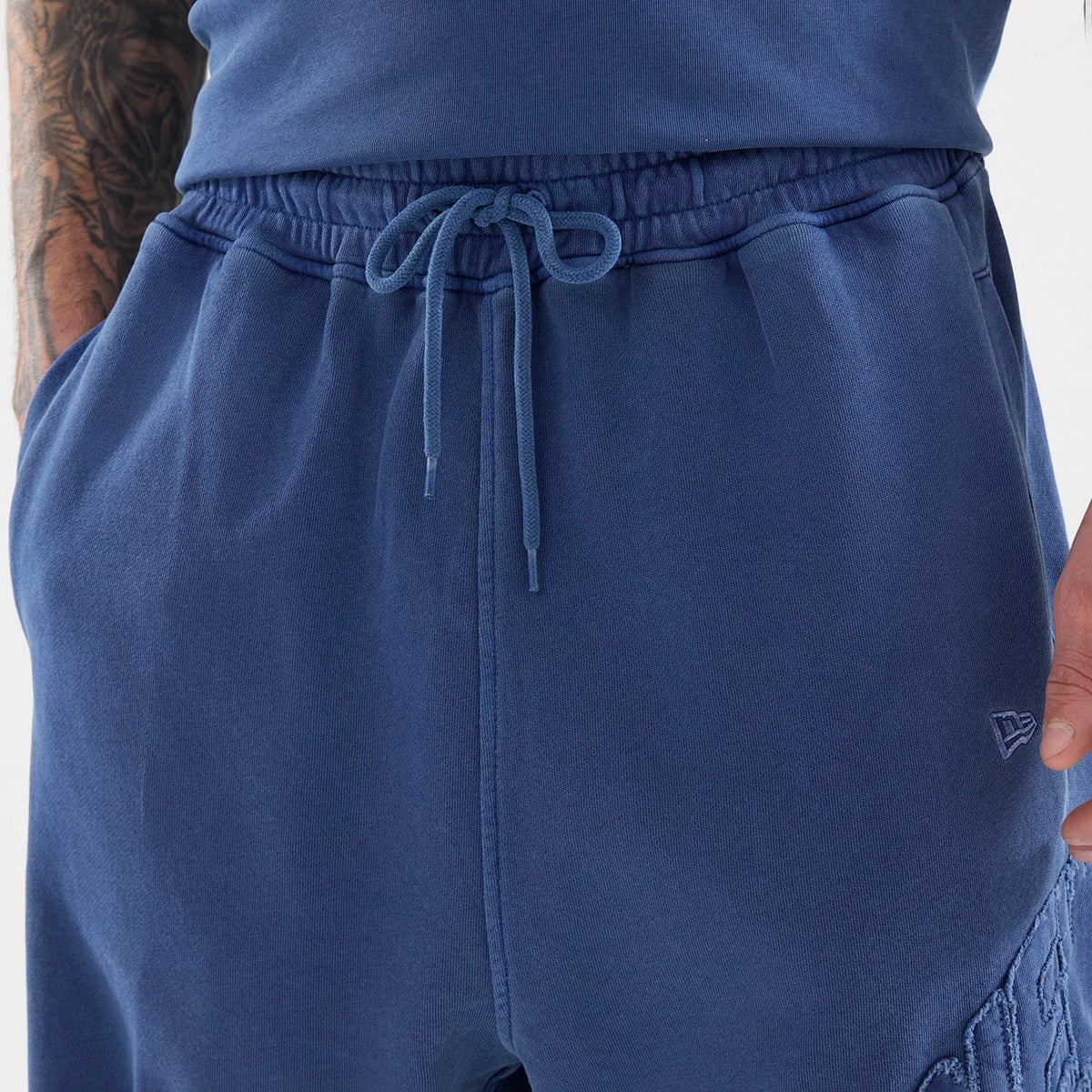 The model is wearing this New Era Street Archived Oversized Shorts in blue. 4