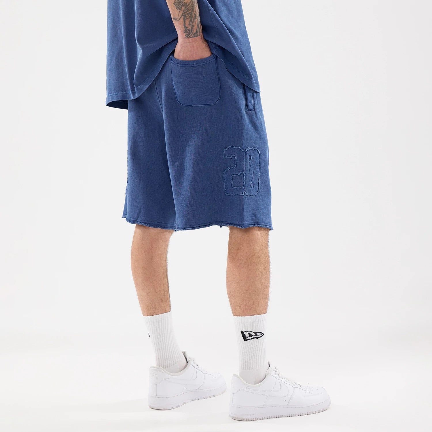 The model is wearing this New Era Street Archived Oversized Shorts in blue. 2
