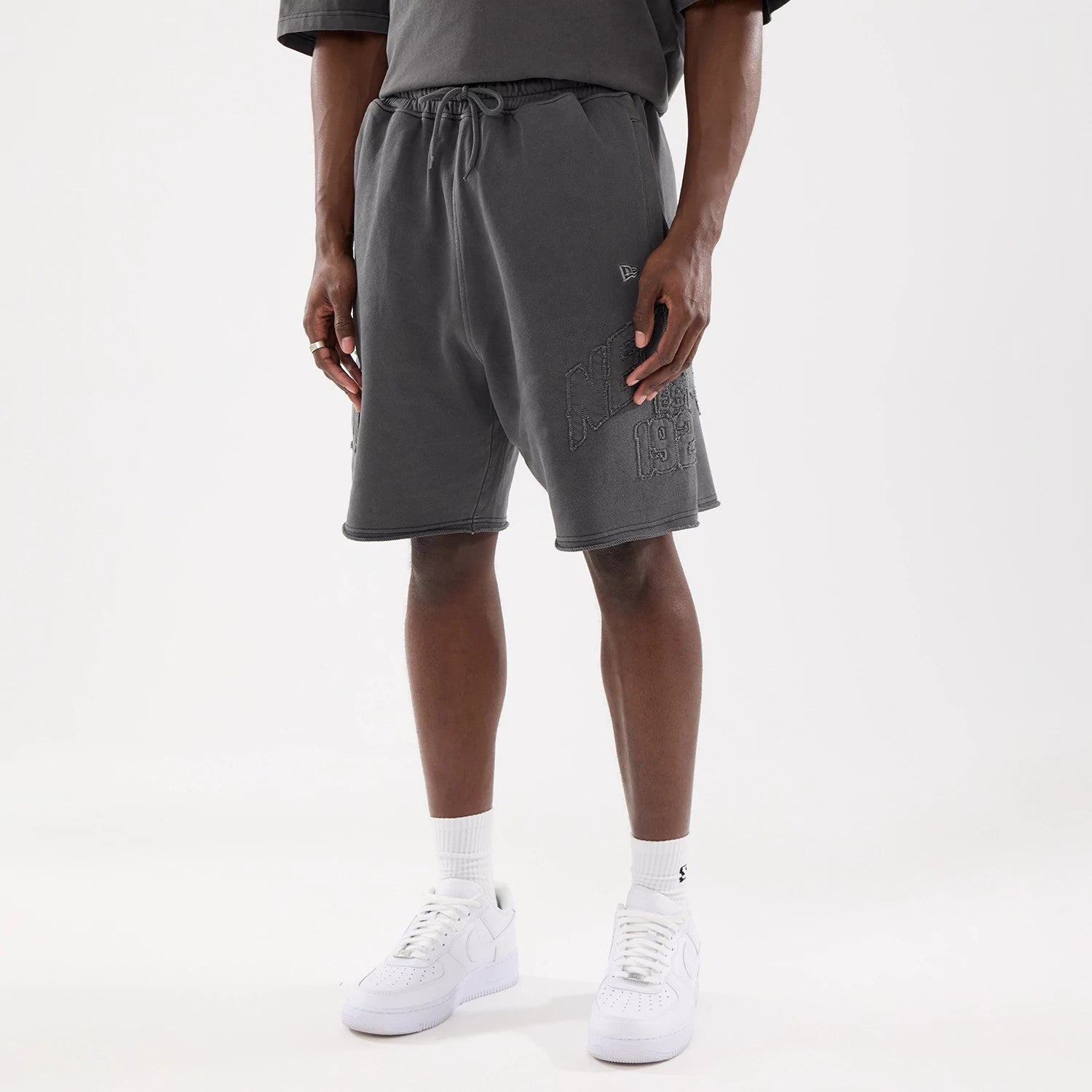 The model is wearing this New Era Street Archived Oversized Shorts in black. 1