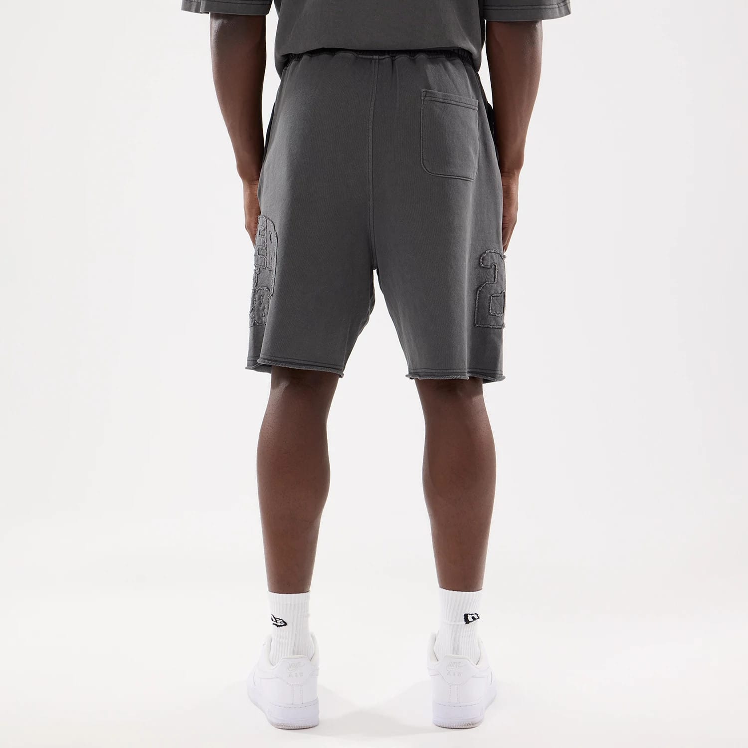 The model is wearing this New Era Street Archived Oversized Shorts in black. 2