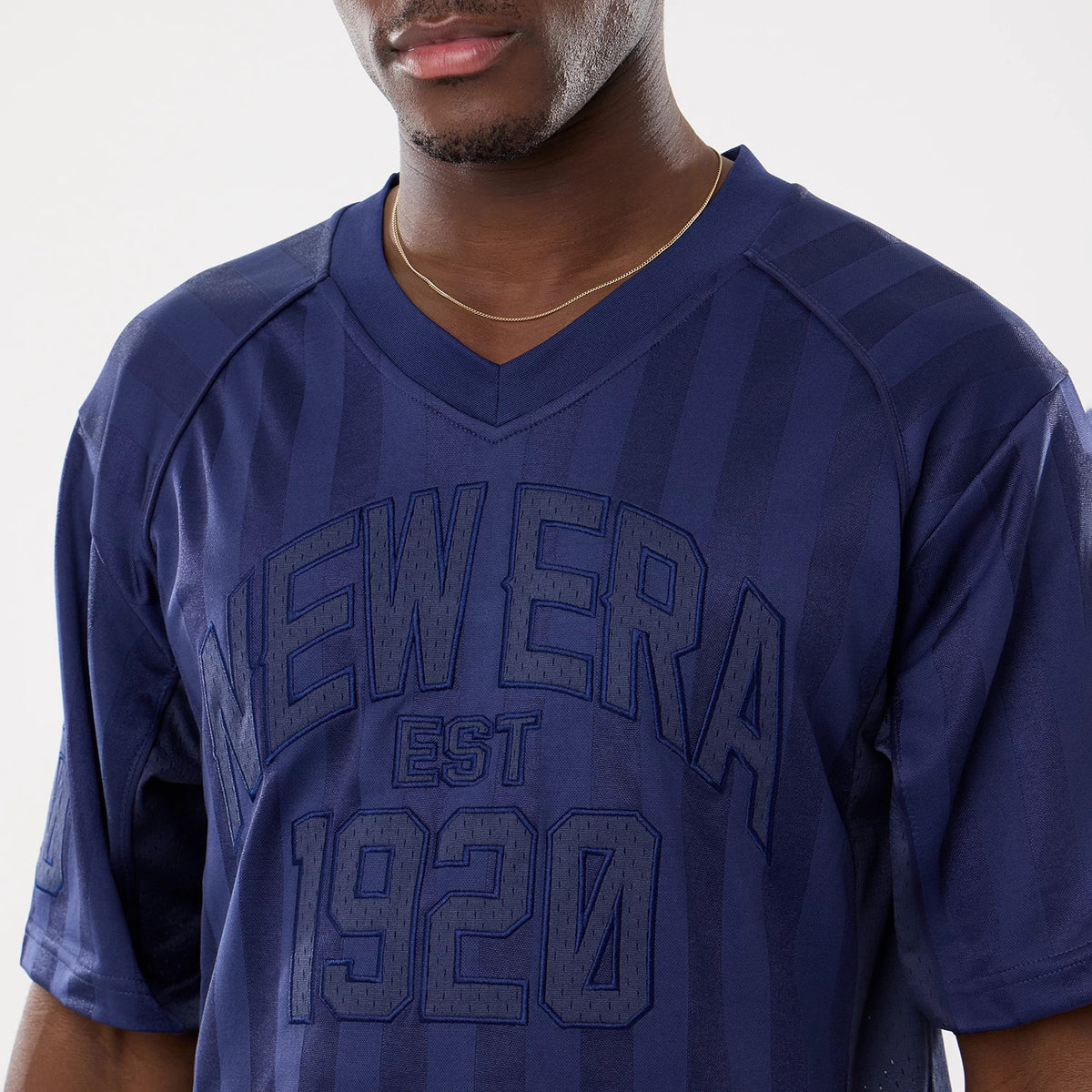 New Era Street Archived Navy Mesh Jersey, front view on a model wearing a gold chain necklace, featuring raised navy New Era EST 1920 lettering across the chest with subtle vertical stripe detailing.