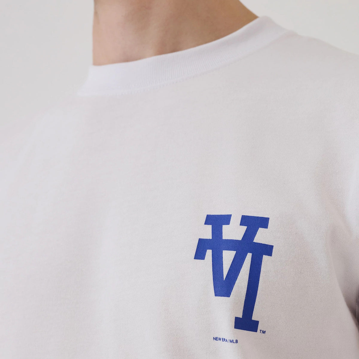 LA Dodgers MLB Upside Down White T-Shirt, front view showing a blue inverted "LA" logo printed on the left chest area, the plain white fabric contrasting with the bold logo beneath the crew neckline.