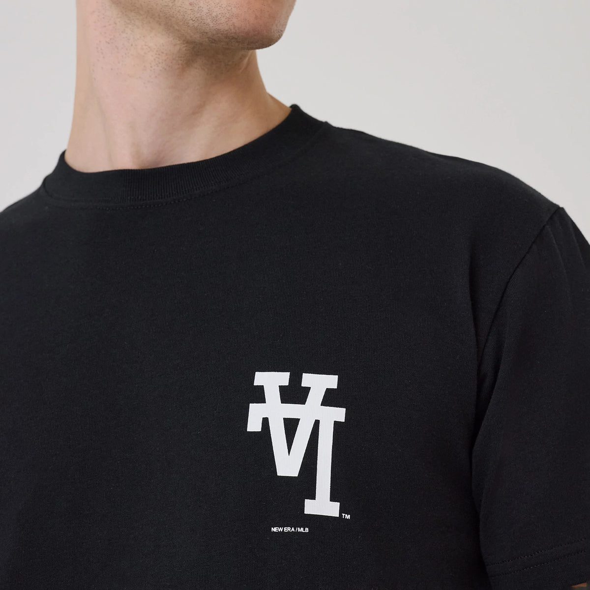LA Dodgers MLB Upside Down Black T-Shirt, on-model view showing the black fabric with a large white LA logo positioned upside down on the chest, and New Era MLB text beneath the logo.
