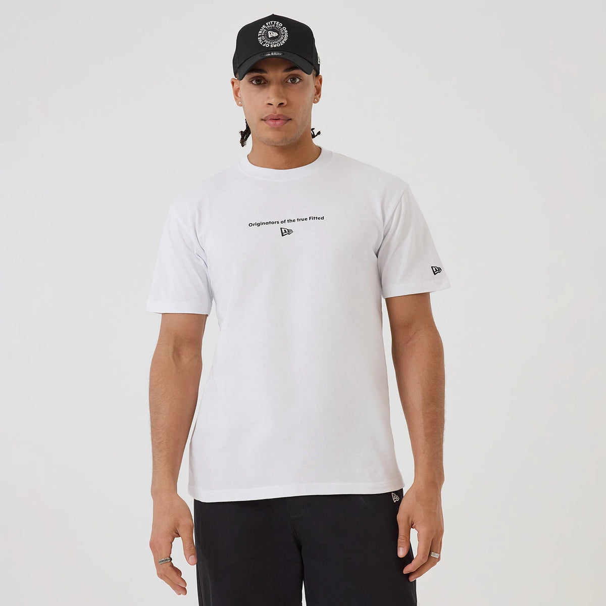 New Era Circle White T-Shirt, on-model view showing the white T-shirt with black text and a debossed New Era logo on the chest, short sleeves and a New Era logo on the left sleeve.