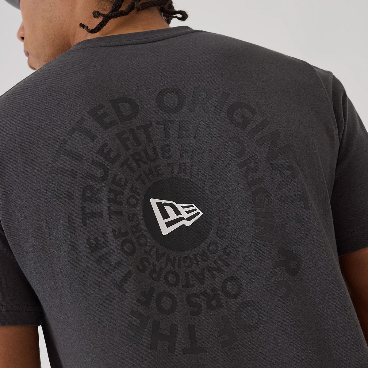 New Era Circle Grey T-Shirt, rear view showing the large circular design on the grey fabric with a debossed New Era logo at the centre surrounded by layered text radiating outwards.