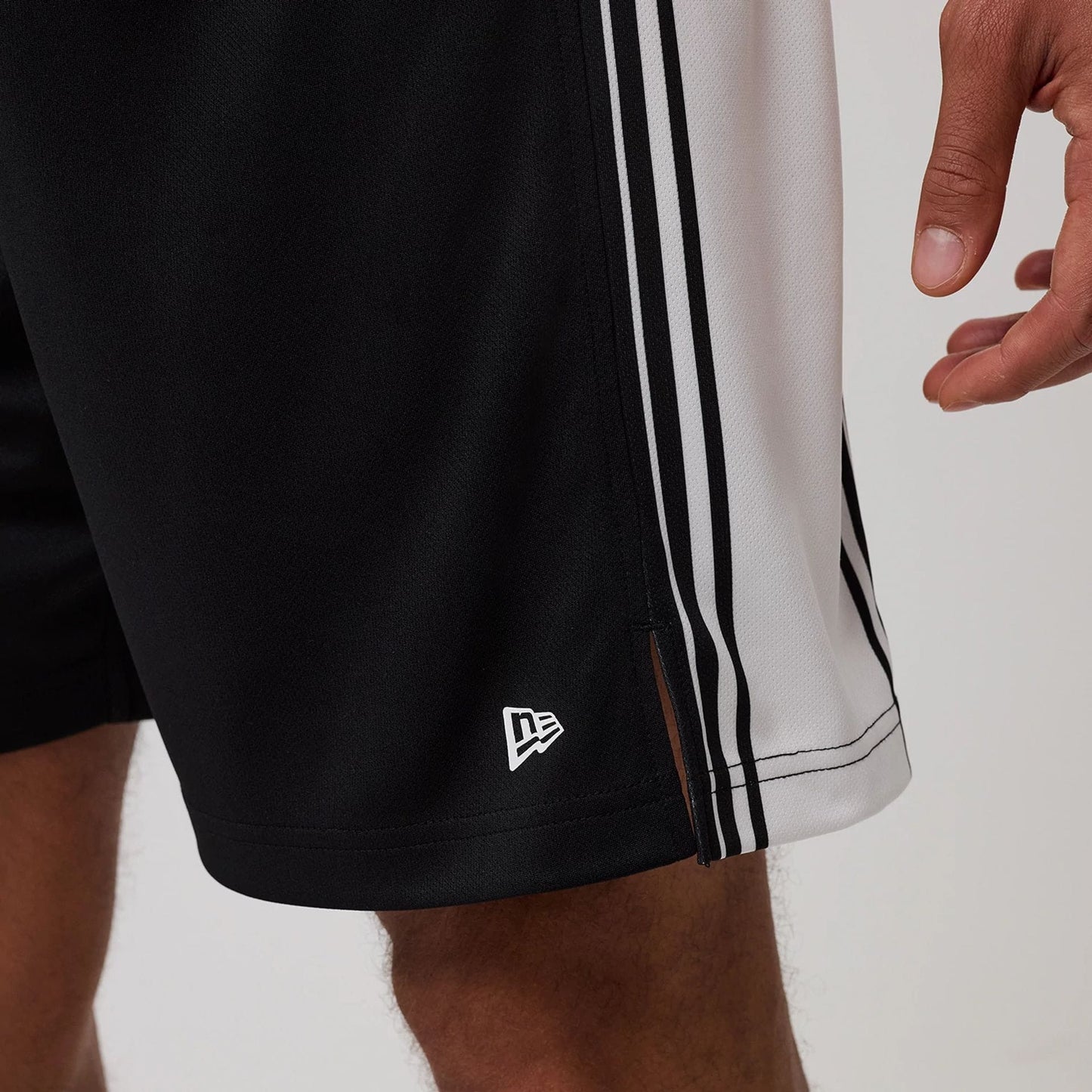 The model is wearing this New Era Mesh Oversized Shorts in black. 7