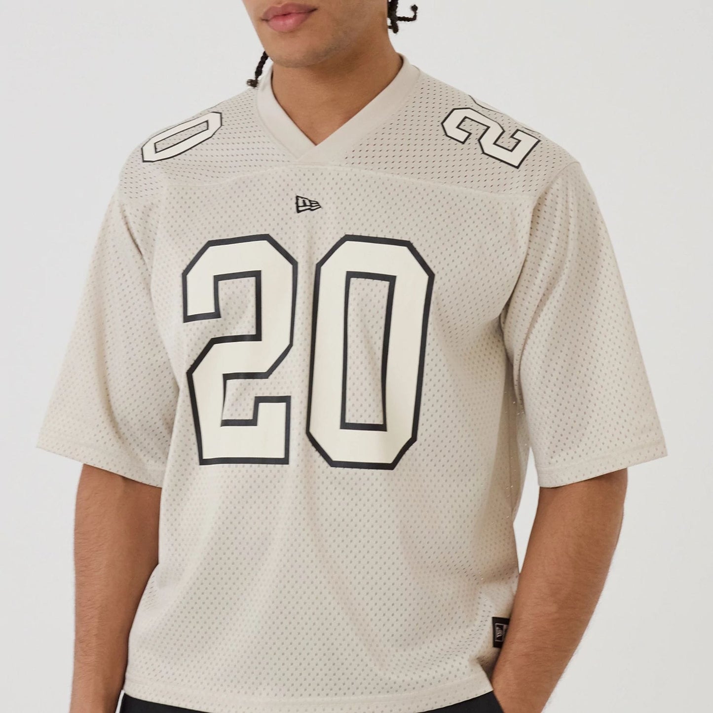 The model is wearing this New Era Mesh Football Short Sleeve Shirt in beige. 7