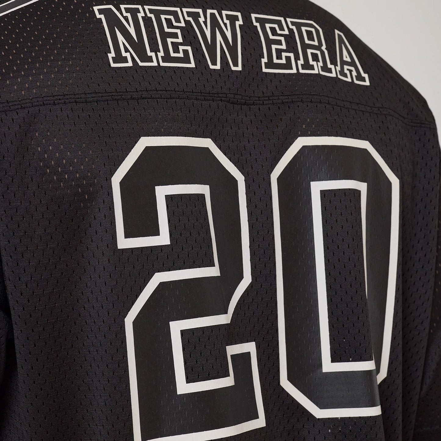 The model is wearing this New Era Mesh Football Short Sleeve Shirt in black. 7