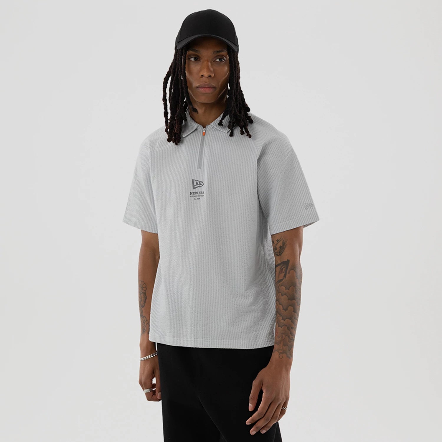 The model is wearing this New Era Seersucker Polo T-Shirt in grey. 1