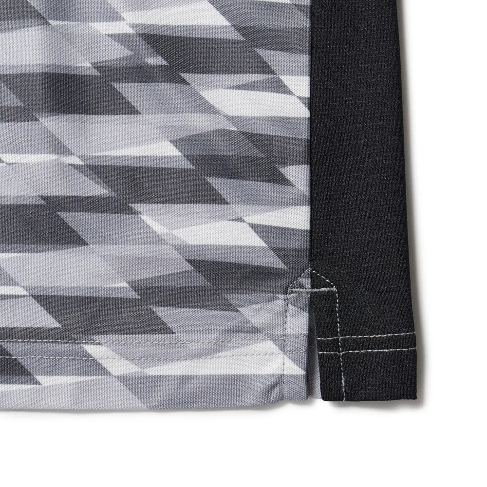 New Era Grid Grey Polo T-Shirt, close-up view showing the geometric grey and white grid pattern on the fabric with a contrast black panel along the side seam and detailed stitching at the hem.
