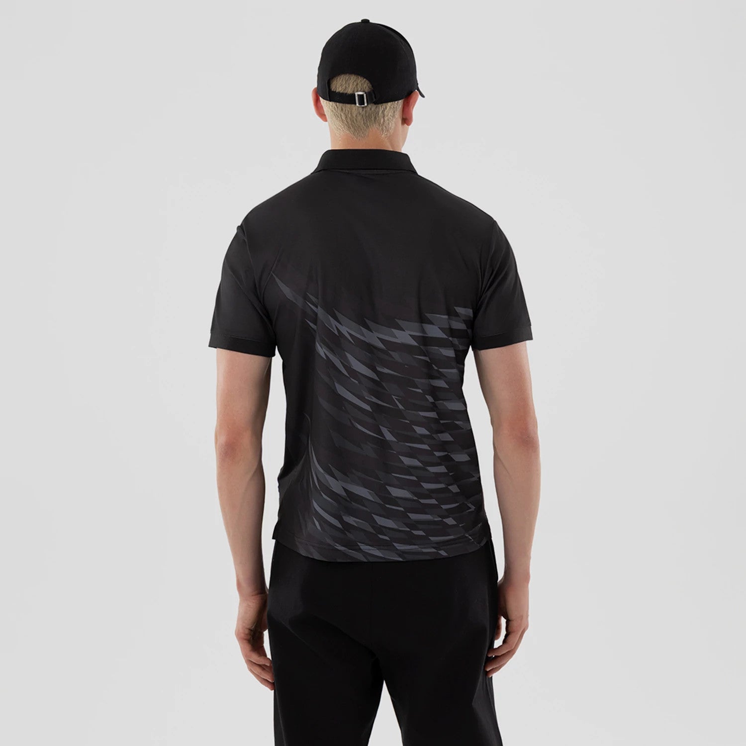 The model is wearing this New Era Grid Polo T-Shirt in black. 2