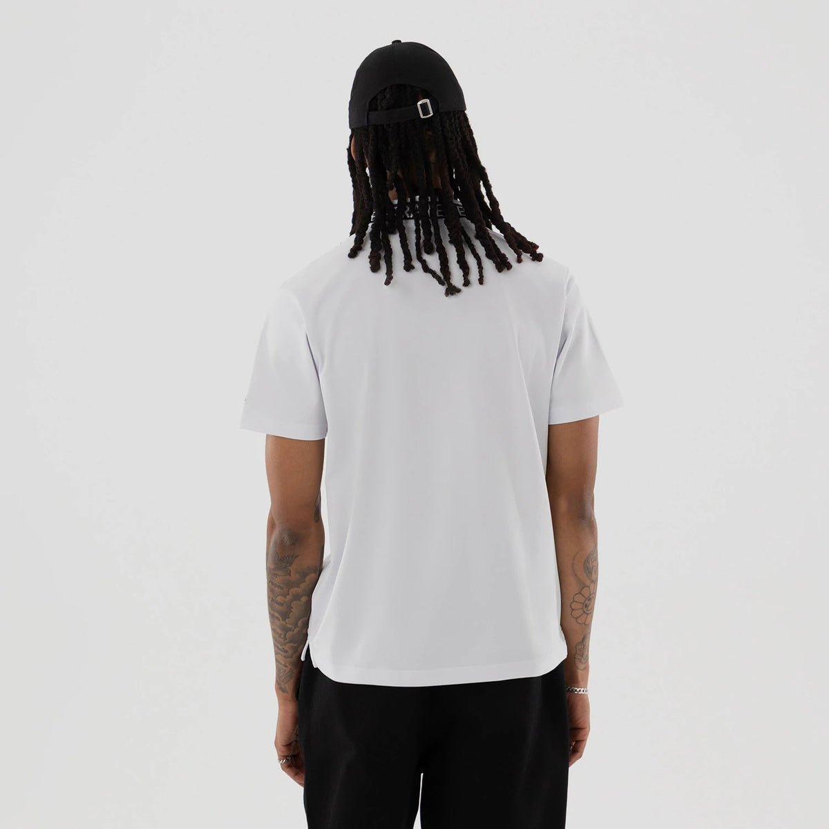 The model is wearing this New Era Kanoko Polo T-Shirt in white. 2