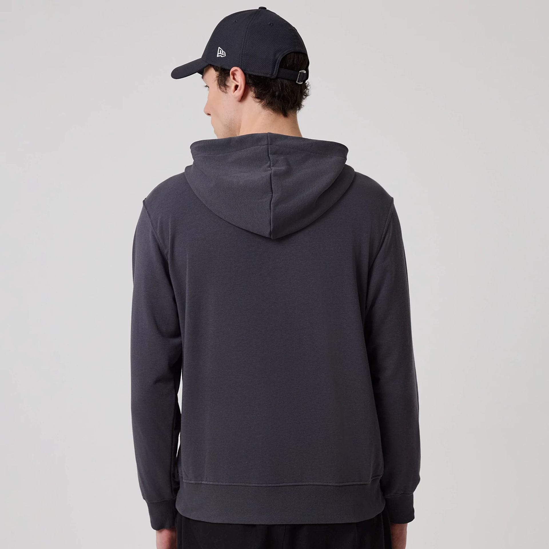 The model is wearing this New Era New York Oversized Pullover Hoodie in dark grey. 2