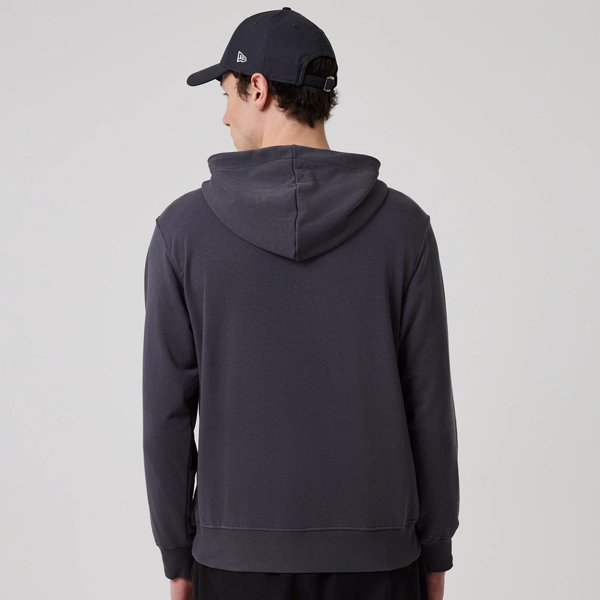 The model is wearing this New Era New York Oversized Pullover Hoodie in dark grey. 2