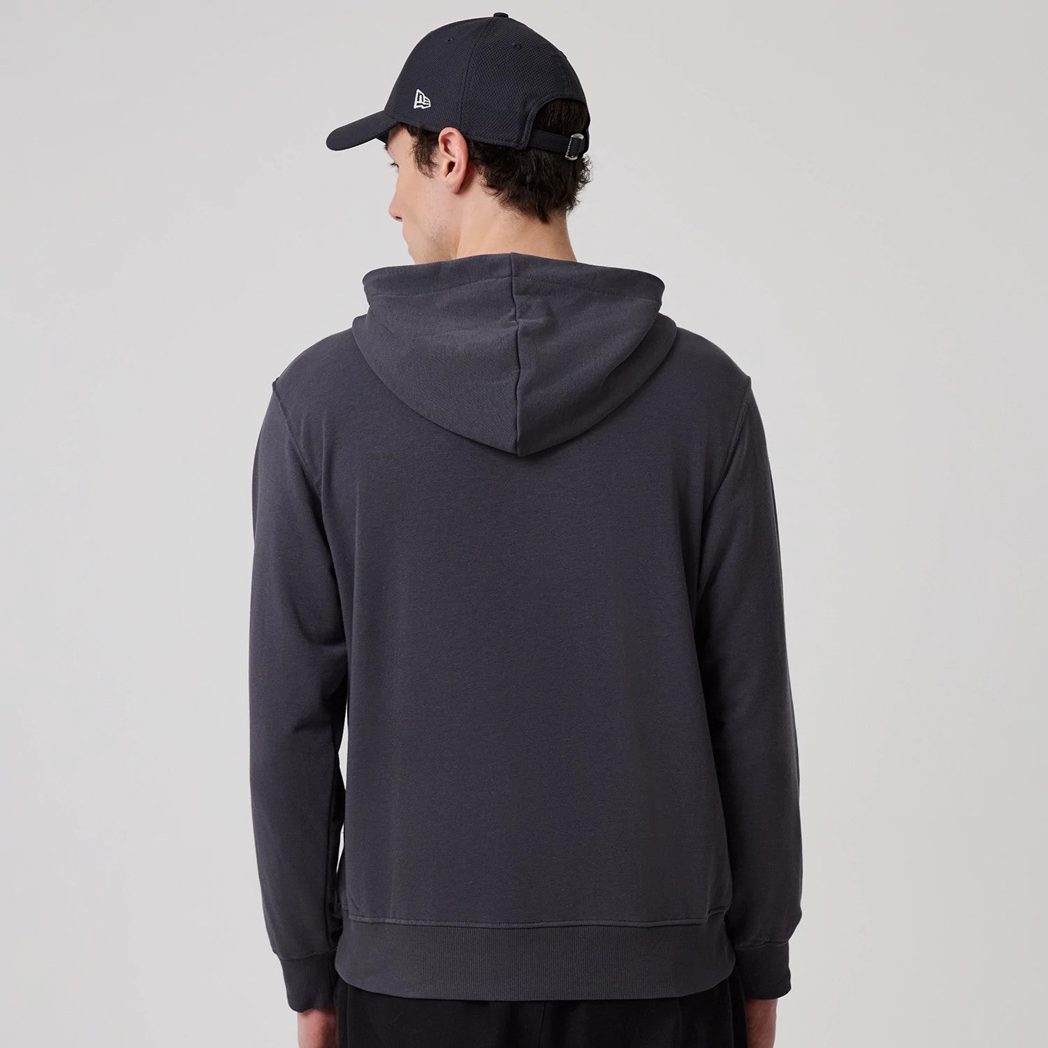 The model is wearing this New Era New York Oversized Pullover Hoodie in dark grey. 2