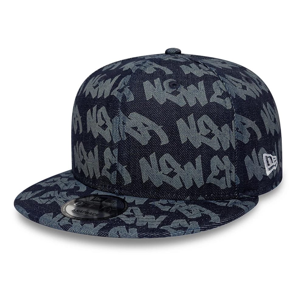 New Era Laser Burnout Denim Navy 9FIFTY Snapback Adjustable Cap, front view with a graffiti-style pattern in grey against the navy denim, a black 9FIFTY size sticker on the flat visor, and the New Era flag logo embroidered on the left side.