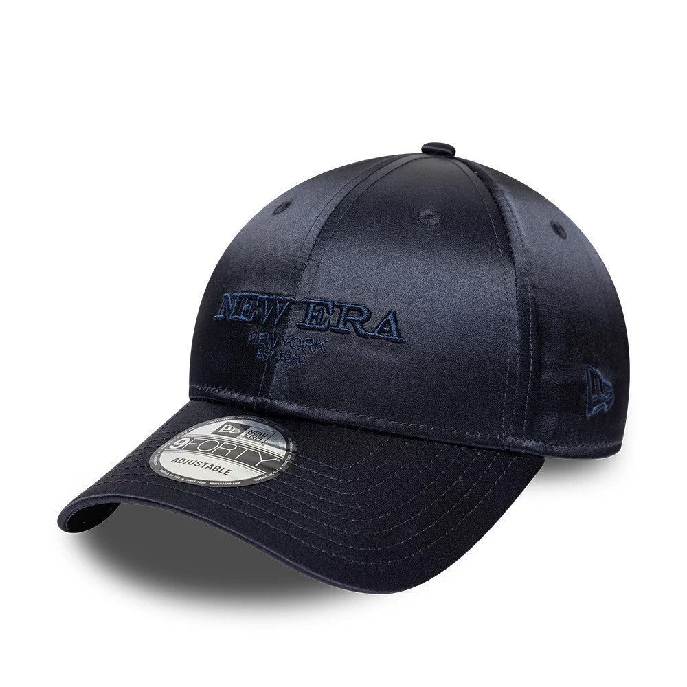 New Era Satin Navy 9FORTY Adjustable Cap, three-quarter view showing navy raised embroidery New Era logo on front panel, matching navy New Era flag logo on left side, with 9FORTY size sticker on the visor.