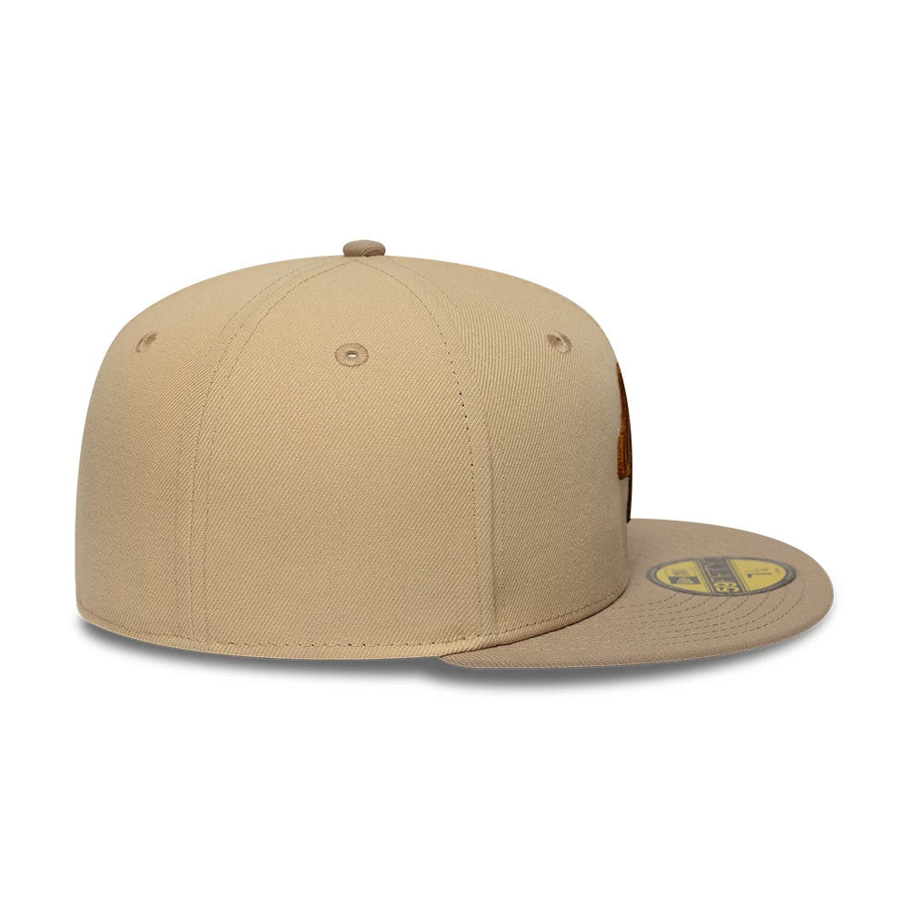New Era Mocha Mousse Light Beige 59FIFTY Fitted Cap, side view showing the structured light beige crown with embroidered eyelets, brown embroidered front logo, and gold 59FIFTY size sticker on the flat visor.