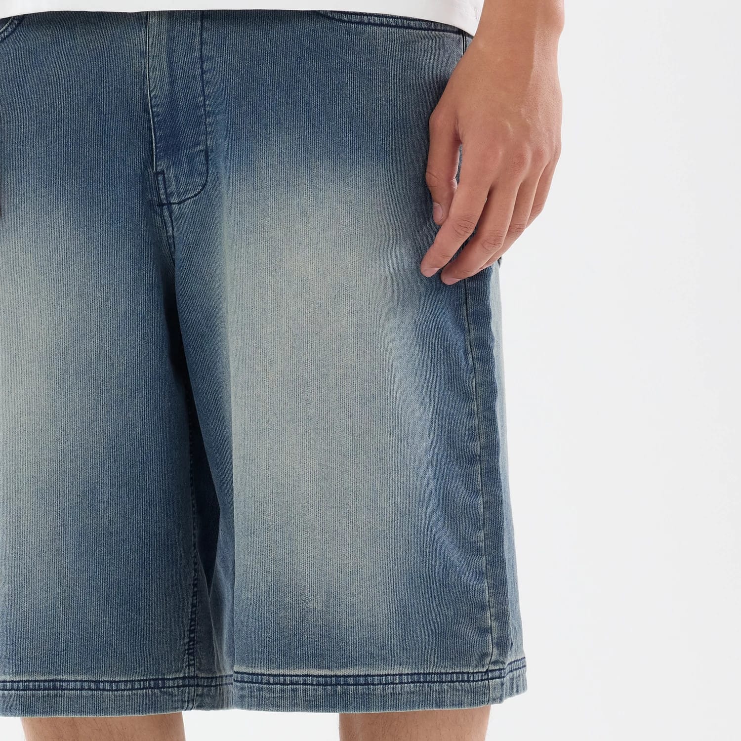 The model is wearing this New Era Washed Bermuda Shorts in blue. 3
