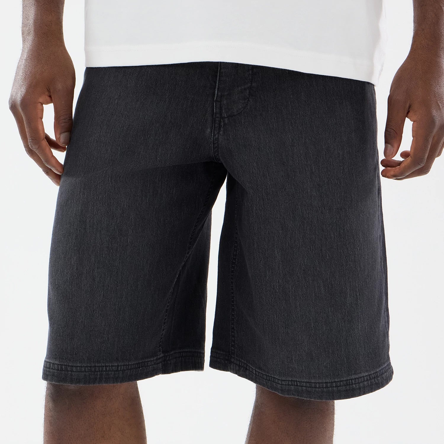 The model is wearing this New Era Washed Bermuda Shorts in black. 3