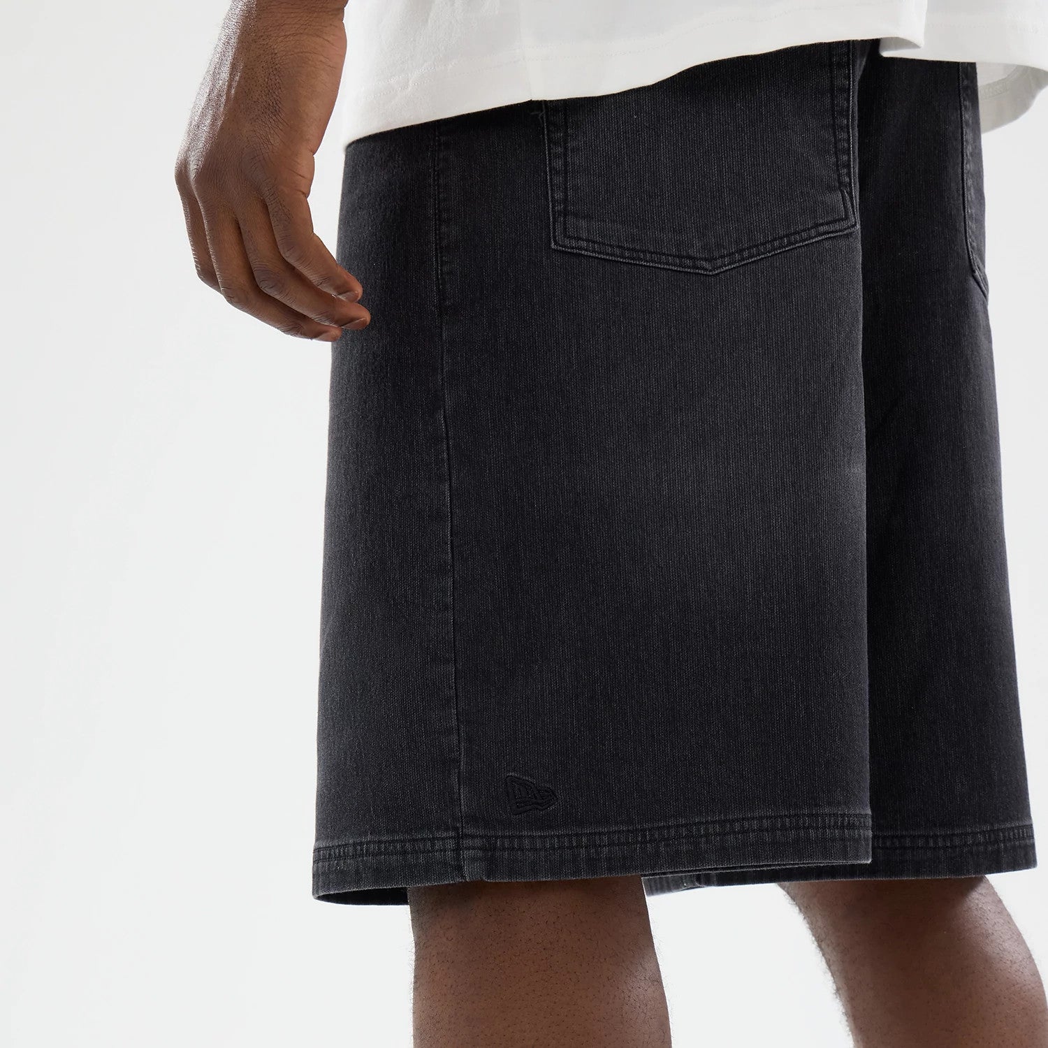 The model is wearing this New Era Washed Bermuda Shorts in black. 4
