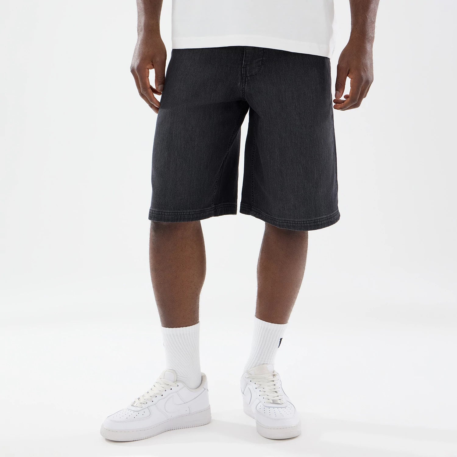 The model is wearing this New Era Washed Bermuda Shorts in black. 1
