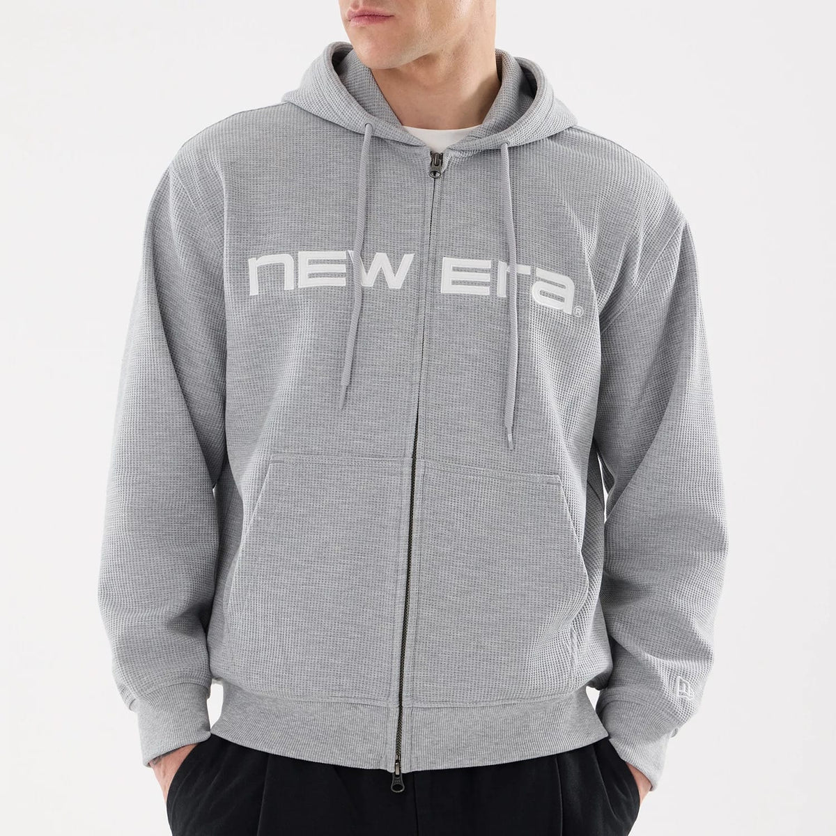 The model is wearing this New Era Waffle Full Zip Hoodie in grey. 3