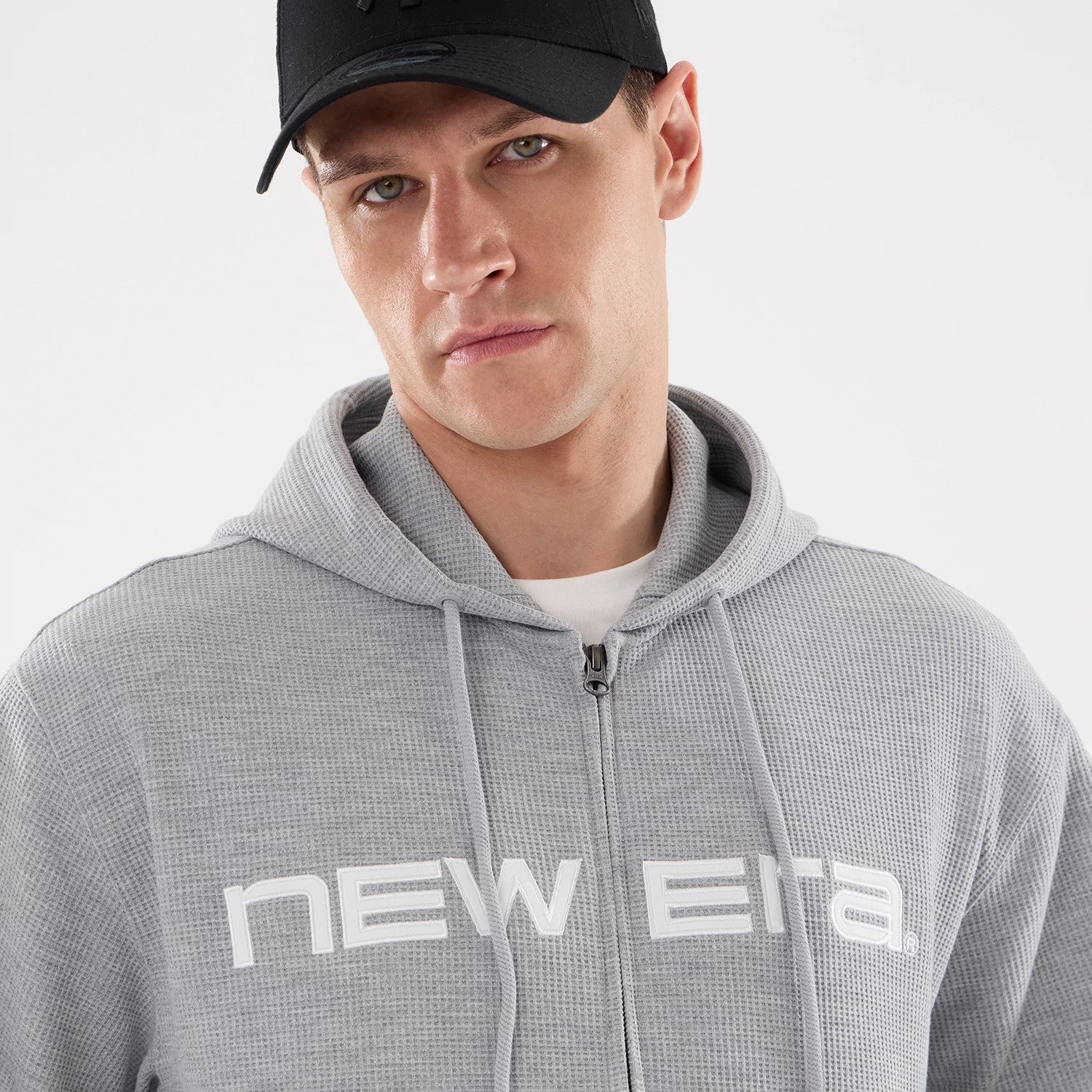 The model is wearing this New Era Waffle Full Zip Hoodie in grey. 4