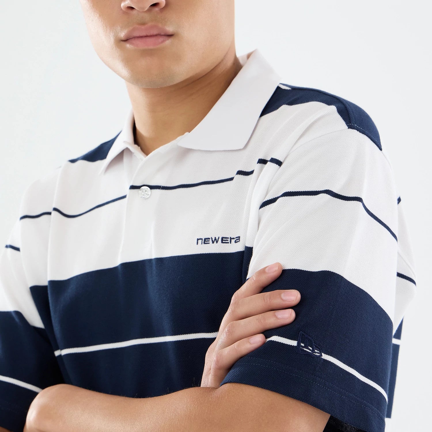 The model is wearing this New Era Stripe Polo T-Shirt in white. 3