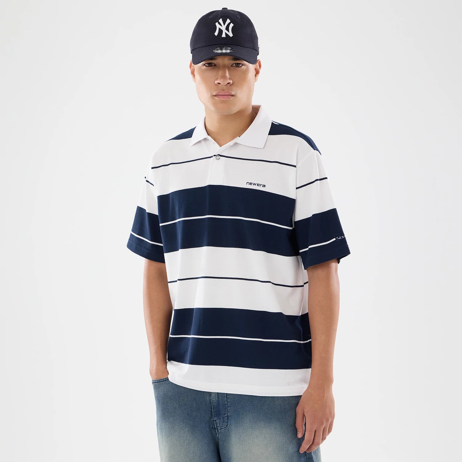 The model is wearing this New Era Stripe Polo T-Shirt in white. 1