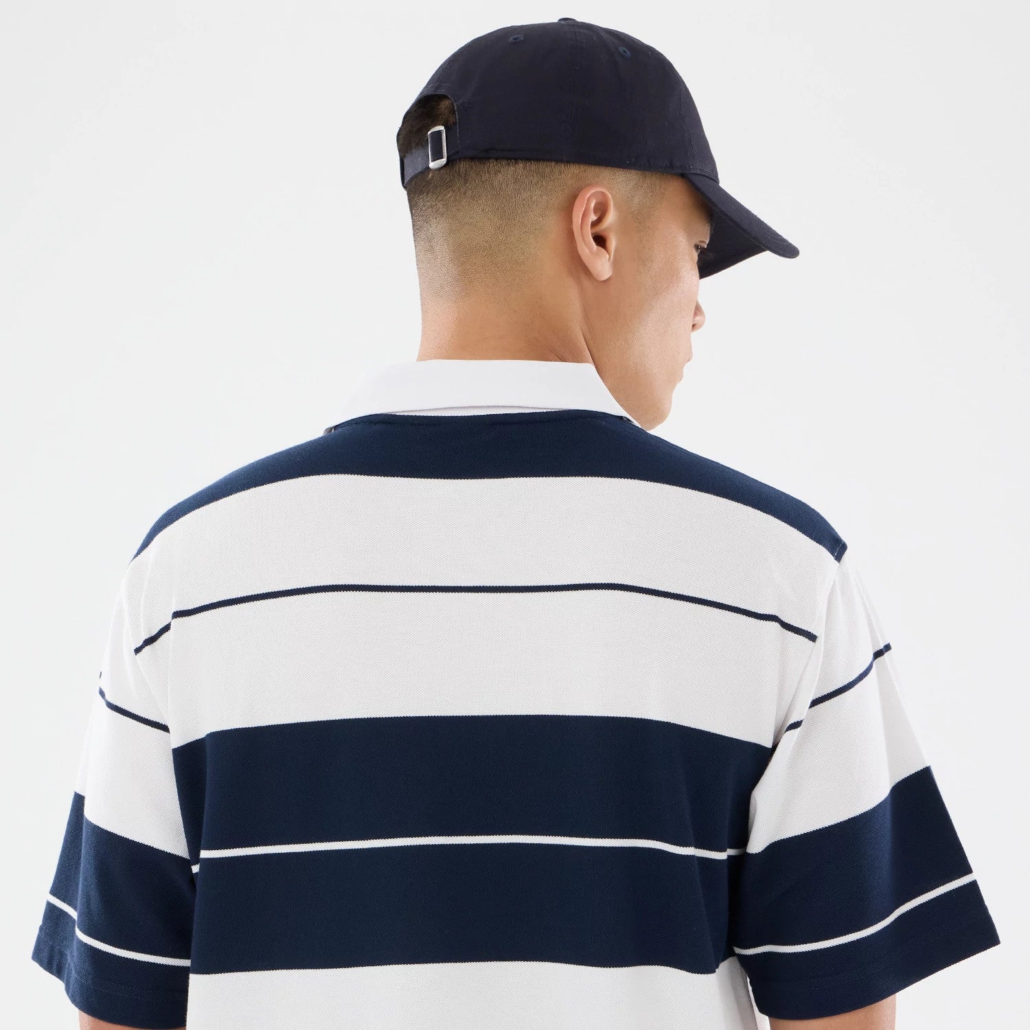 The model is wearing this New Era Stripe Polo T-Shirt in white. 4
