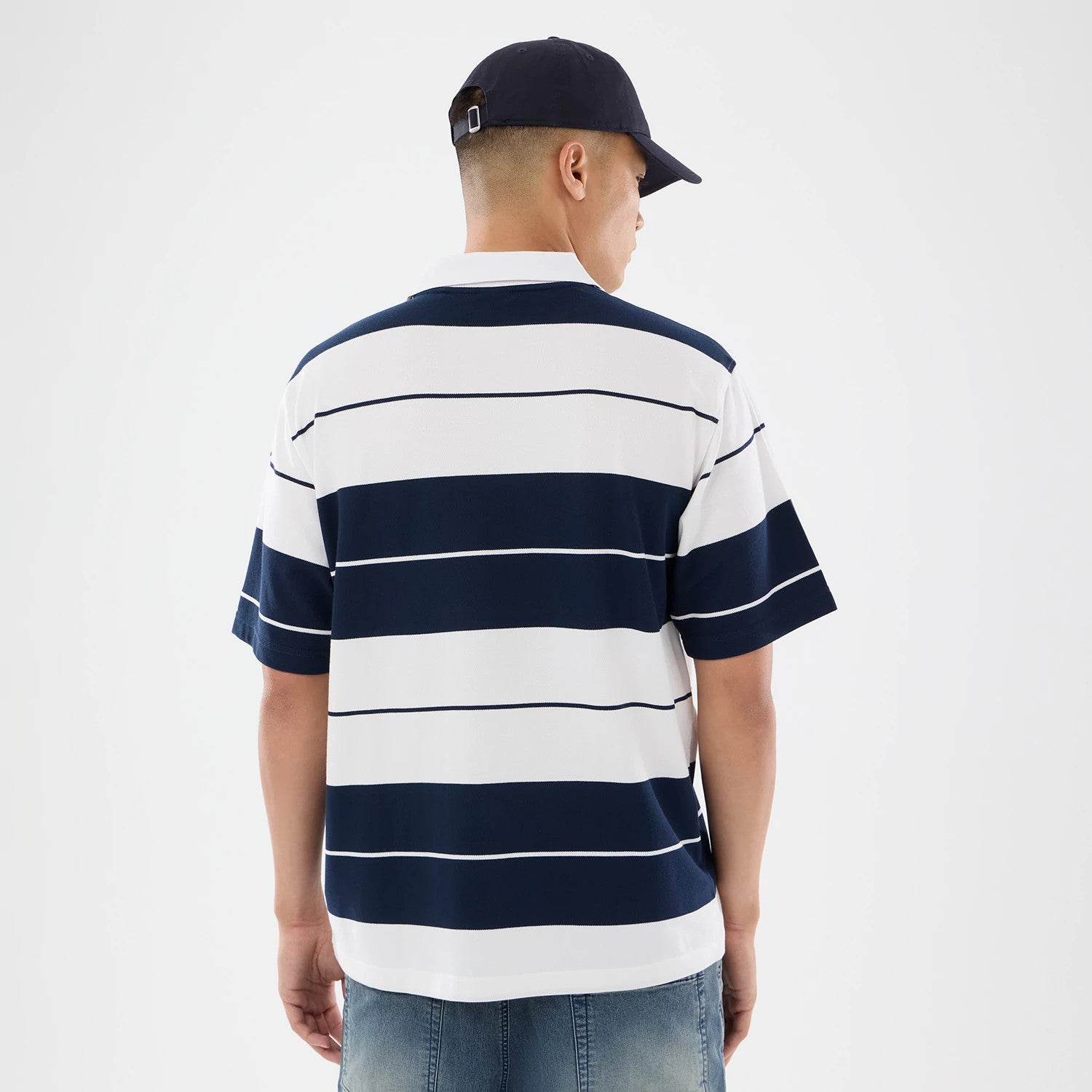The model is wearing this New Era Stripe Polo T-Shirt in white. 2