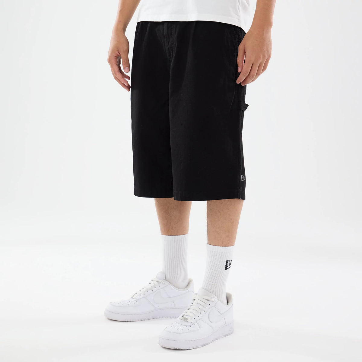 The model is wearing this New Era Canvas Bermuda Shorts in black. 1