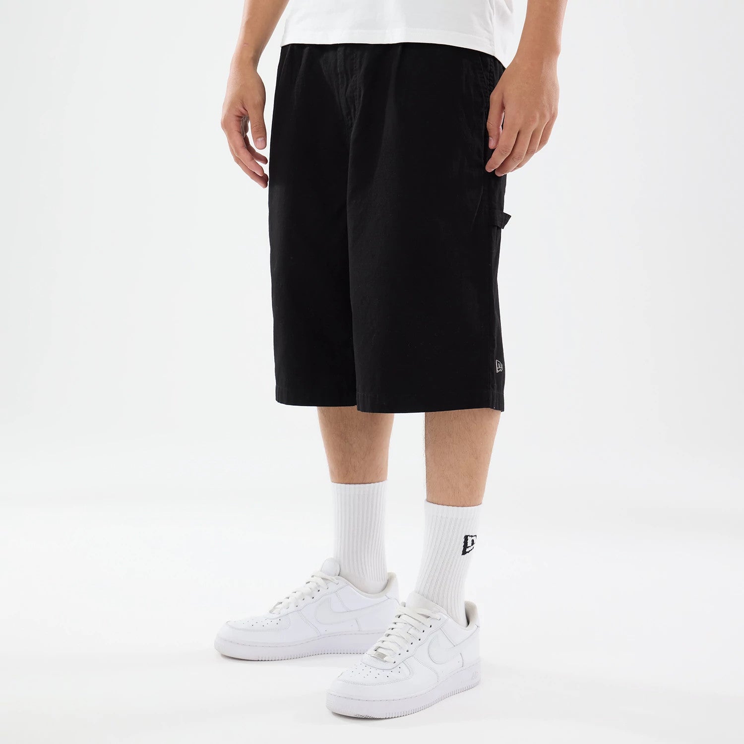 The model is wearing this New Era Canvas Bermuda Shorts in black. 1