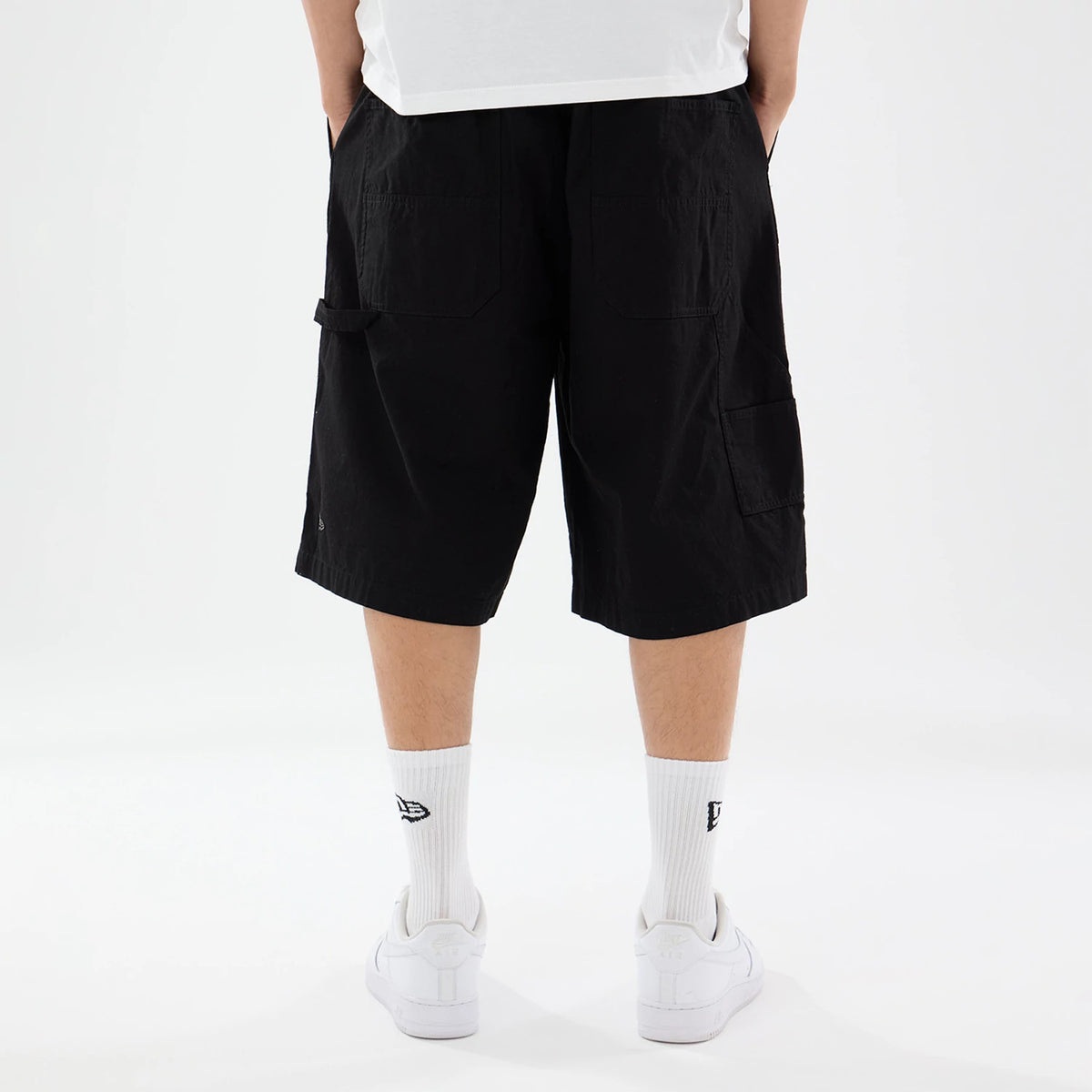 The model is wearing this New Era Canvas Bermuda Shorts in black. 2